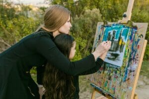 Imagen de una mujer pintando con un niño pequeño al aire libre | Cosas que hacer en Boulder con niños pequeños. Visita familiar a Boulder, Colorado.